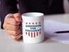 businessman sitting at desk with a white mug with red white and blue American design with typography that says Anderson for America with Red Stars and Stripes