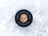 hockey puck on top of ice with a first fathers day baby photo design with the name Hunter Drake printed on it