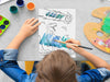 kid painting a canvas panel with a custom name dinosaur t-rex design printed on it, kid is using watercolors on grey table surrounded by painting supplies such as cups of paint, palettes, brushes, etc