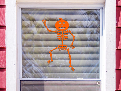 Dancing Pumpkin Skeleton sticker (in orange) is shown stuck to the exterior of a window.