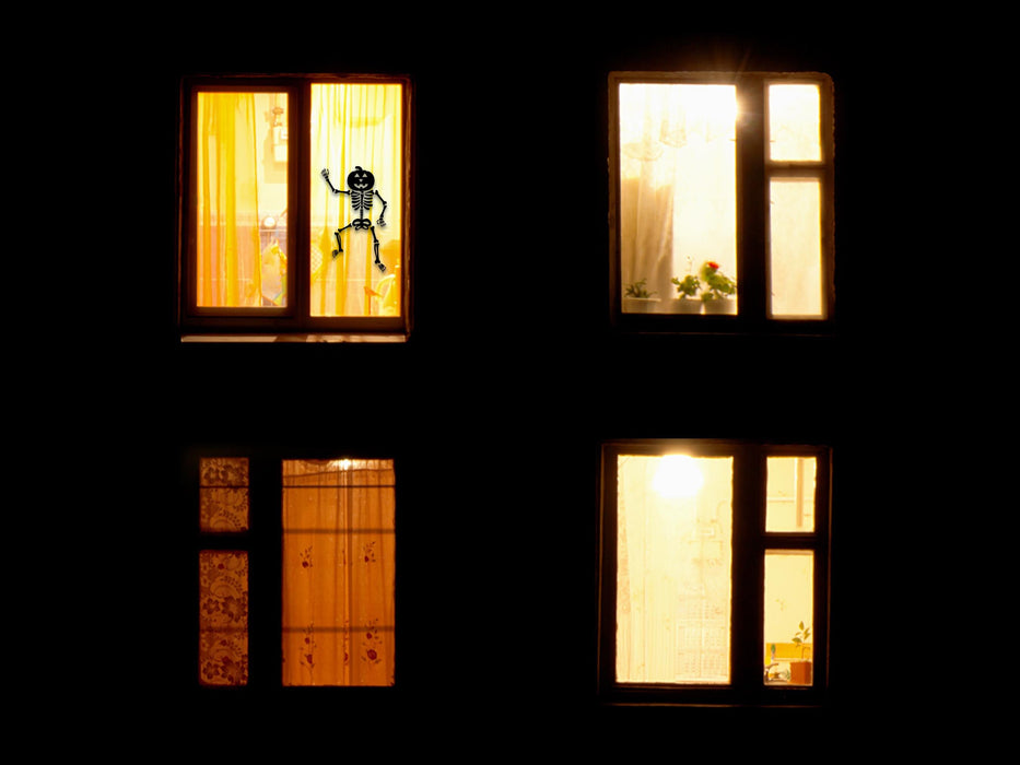 Dancing Pumpkin Skeleton sticker (in black) is shown stuck to the exterior of an apartment window.