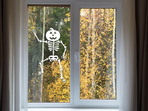 Dancing Pumpkin Skeleton sticker (in white) is shown stuck to the interior of a window.