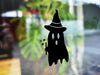 Ghost Witch sticker (in black) is shown stuck to the exterior of a window.