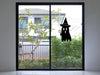 Ghost Witch sticker (in black) is shown stuck to the interior of a glass door.