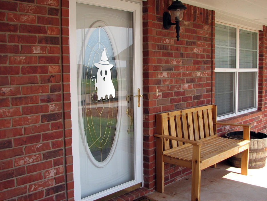 Ghost Witch sticker (in white) is shown stuck to the exterior of a glass door.