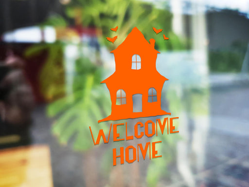 Haunted Welcome Home sticker (in orange) is shown stuck to the exterior of a window.