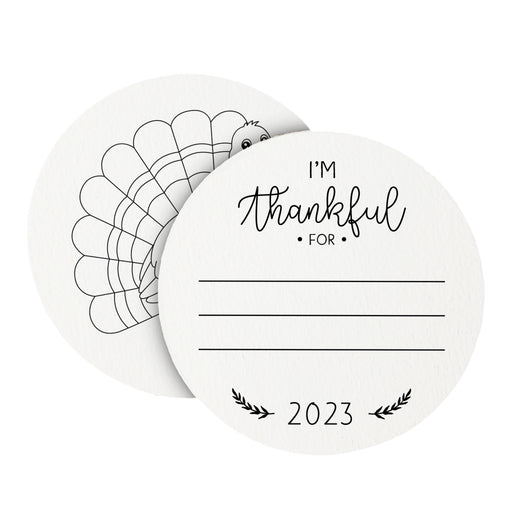 Front and back of coasters shown on a white background. Front of coasters show the text I'm thankful for, has lines for writing in a response, and current year. Back of round coasters feature a turkey illustration.