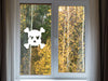 Skull and Crossbones sticker (in white) is shown stuck to the interior of a window.