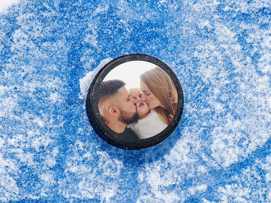 single custom photo hockey puck with a picture of a happy family sitting ontop of a blue ice rink