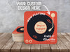 Custom design coasters are shown on a wooden surface. These coasters feature a submitted, custom design.