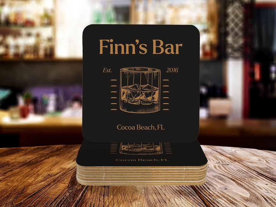 Single coaster sits on top of a stack of coasters. Coasters feature bar design. This design uses brown and orange lettering, and a drawing of beer glasses. The name, established date, and location can be customized.