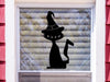 Witch Cat sticker (in black) is shown stuck to the exterior of a window.