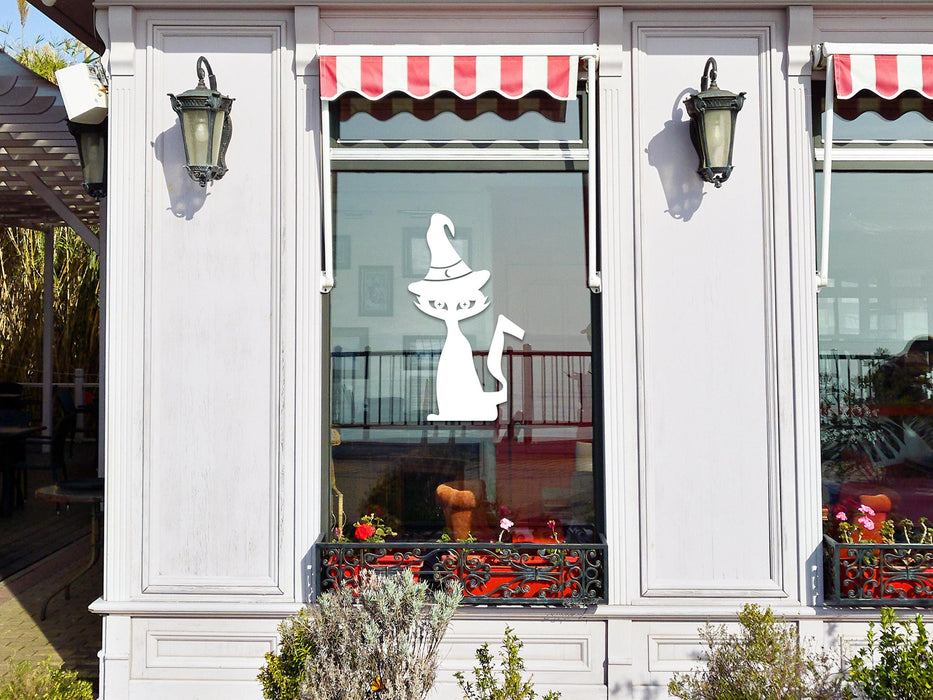 Witch Cat sticker (in white) is shown stuck to the exterior of a storefront window.