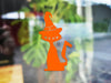 Witch Cat sticker (in orange) is shown stuck to the exterior of a window.