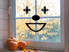 Clown sticker (in black) is shown stuck to the interior of a window.