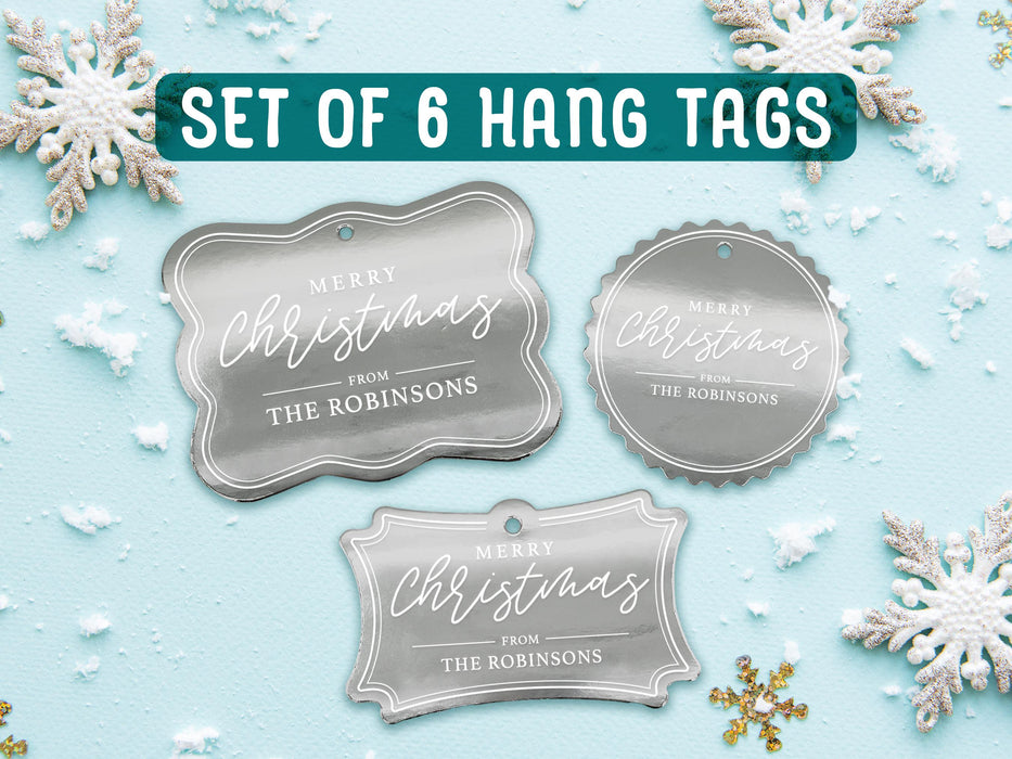 Text reads, Set of 6 Hang Tags. Six silver foil cardstock Merry Christmas gift tags are shown on a light blue surface surrounded by snowflakes.