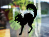 black cat silhouette vinyl sticker in front of a blurred background