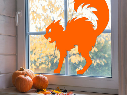 cat silhouette vinyl sticker placed on interior window next to pumpkins and fall leaves