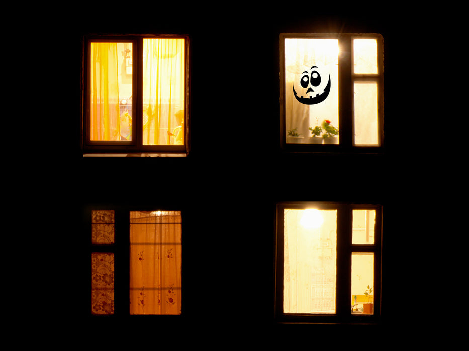 black goofy pumpkin face on outdoor window during nighttime 