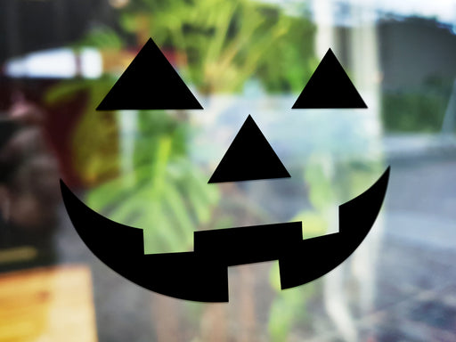 happy pumpkin face vinyl sticker on a blurred background 