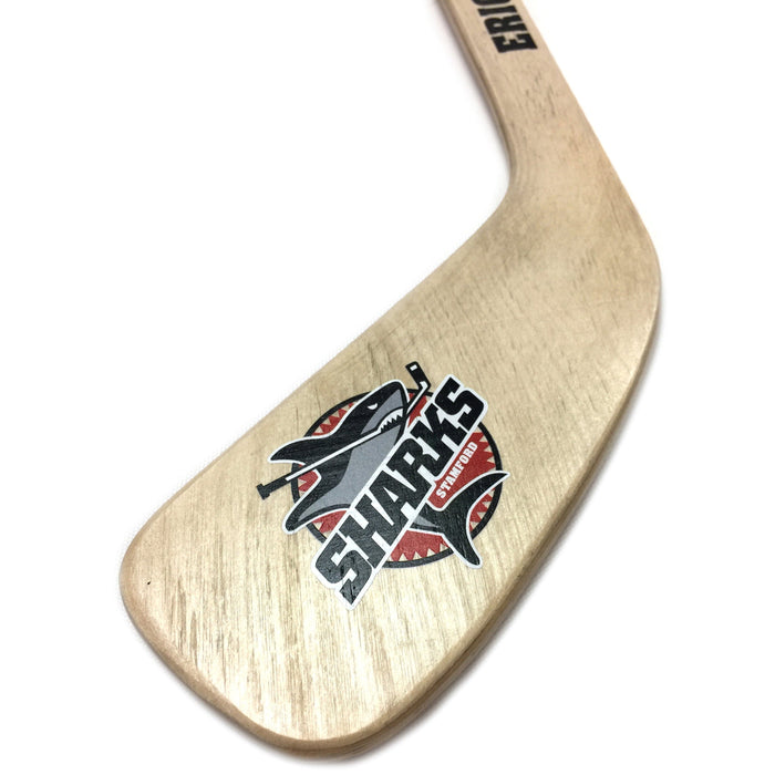 close up of a wooden hockey stick with a printed sharks logo