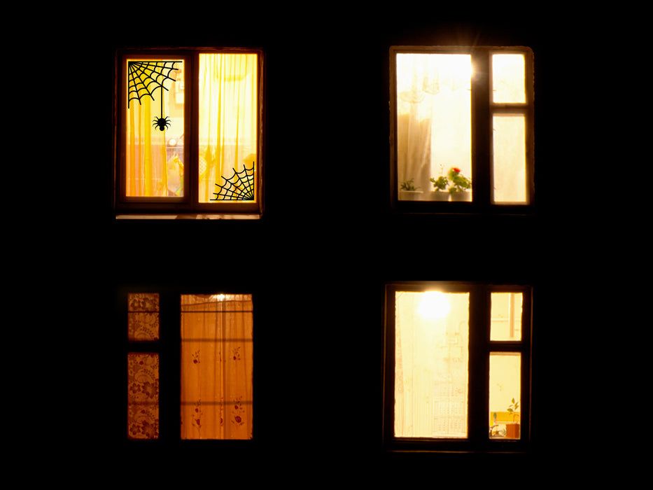 spider web vinyl sticker on an outdoor window during nighttime