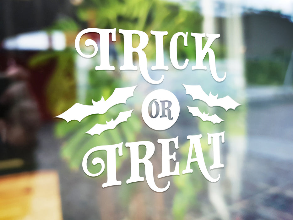 white trick or treat vinyl sticker in front of a blurred background